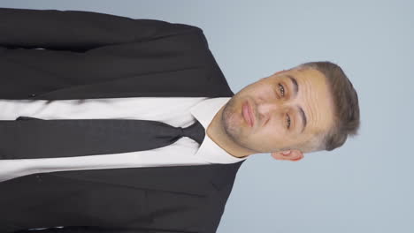 Vertical-video-of-Bored-businessman-looking-at-camera-unhappy.